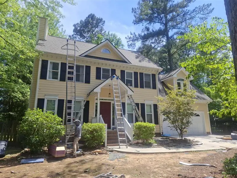 Roof repair technician setting up a ladder to inspect a roof