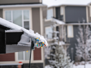Holiday lights on gutter system in snow