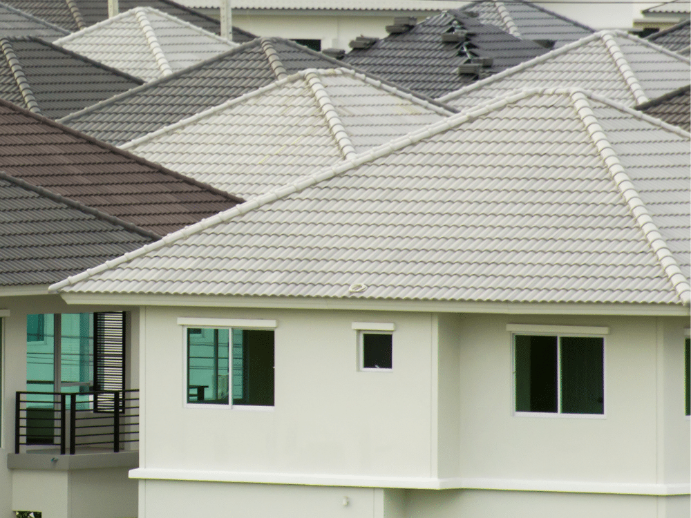 Houses with white stucco siding and white gray roofs or brown roofs