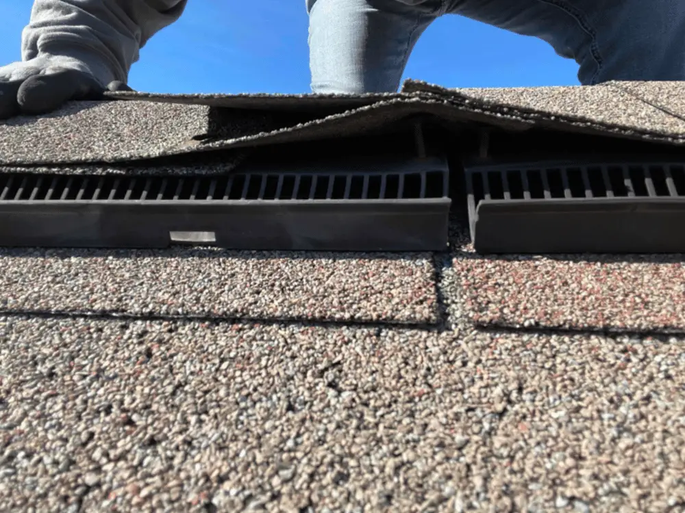 Technician inspects roof nail pop on ridge vent