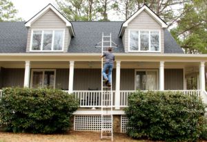 Technician climbs ladder for roof inspection