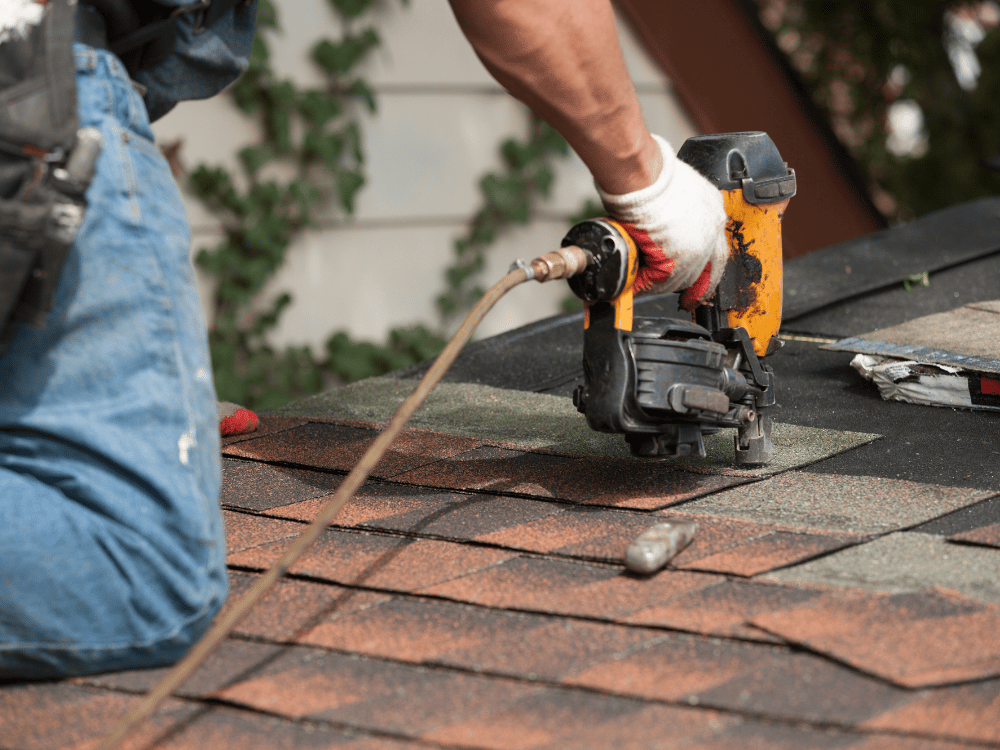 Up close photo of roofing contractor installing asphalt shingles