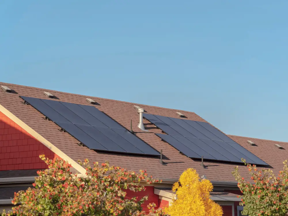 Two-sets-of-solar-panels-on-a-large-asphalt-roof-with-skylights - Artisan Quality Roofing Two sets of solar panels on a roof with roof penetrations