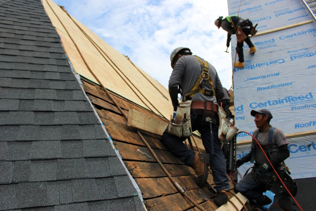 Roofing crew installs roof sheathing on church roof