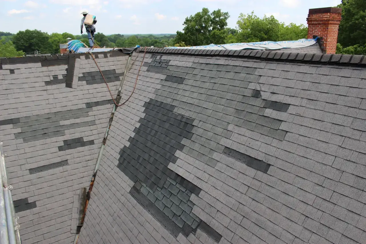 Roof technician-on-roof-peak-getting-asphalt- shingle-