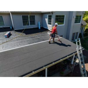 Roofer rolling flintastic on a roof
